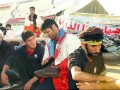 عکس -- قهرمان جهان در حال واکس زدن کفش زائران اربعین حسینی ع